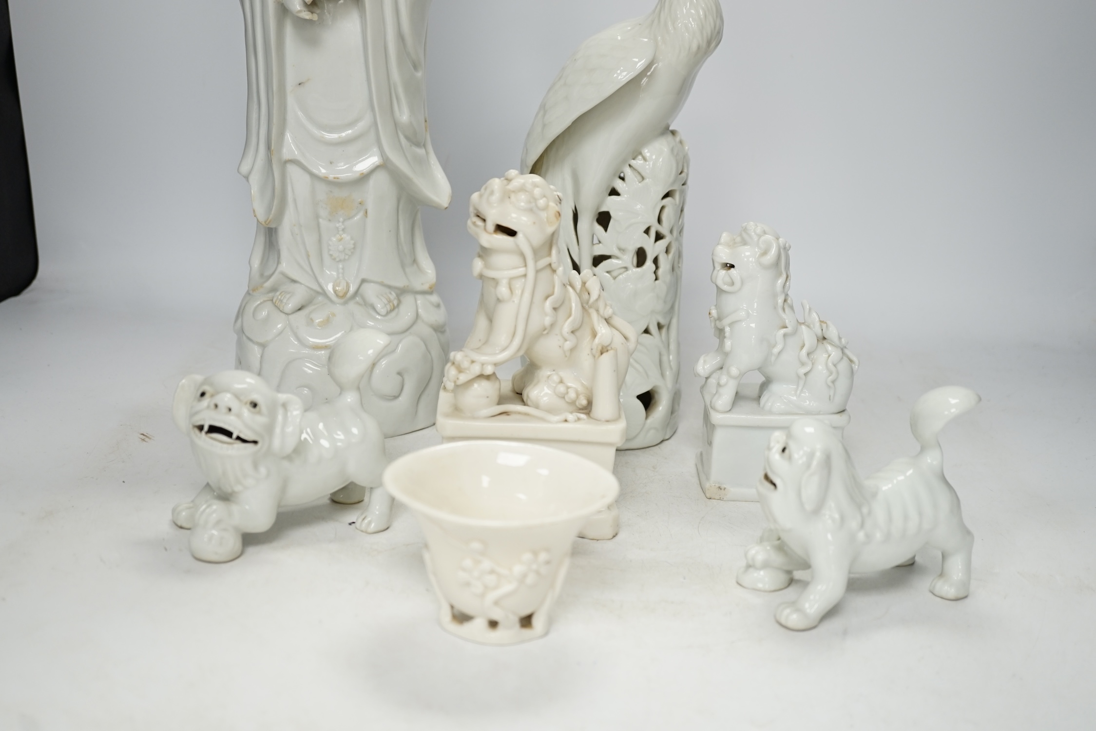 Seven Chinese blanc de chine pieces to include a pair of lion dogs and a phoenix, 17th century and later, largest 44cm high. Condition - varies, poor to fair